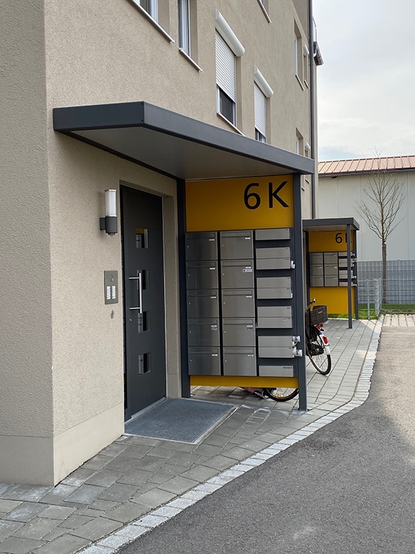 Haustürüberdachung abgeschrägt mit Seitenwand aus Trespa mit farbigen Trespaelementen