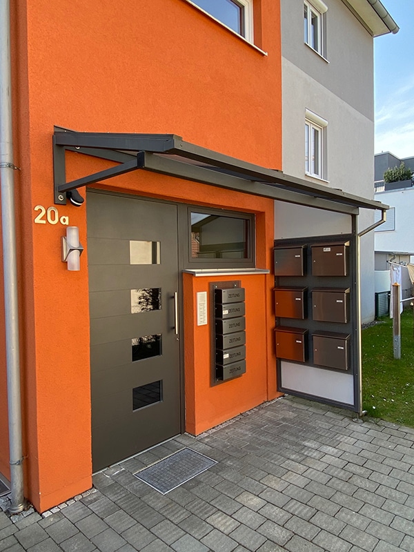Haustürüberdachung mit matter Glasfüllung und Seitenwand mit angebrachtem Briefkasten