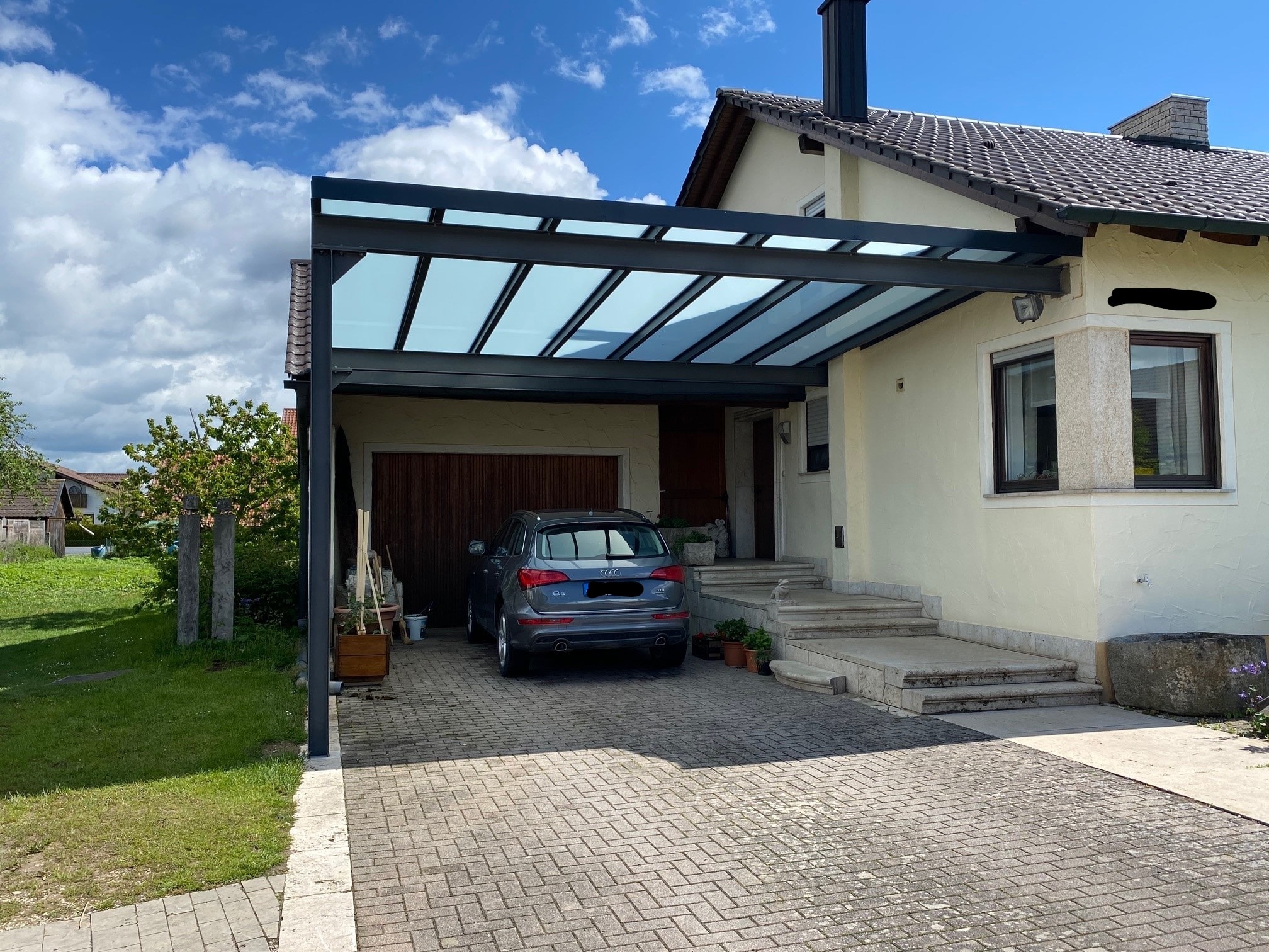 Carport vor Garage mit Glasfüllung