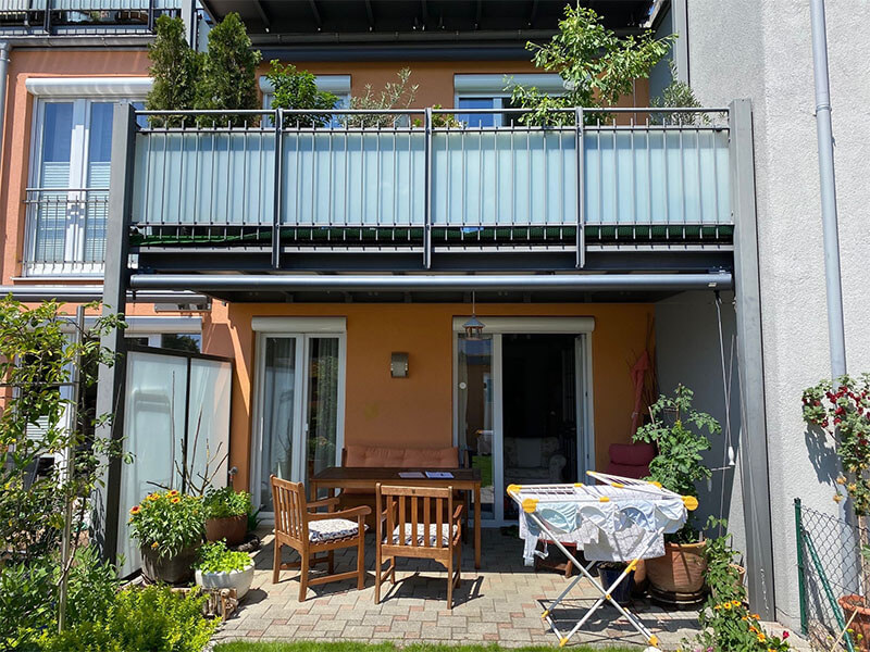 Balkon mit Stabgeländerfüllung und matter Rückseitenverglasung